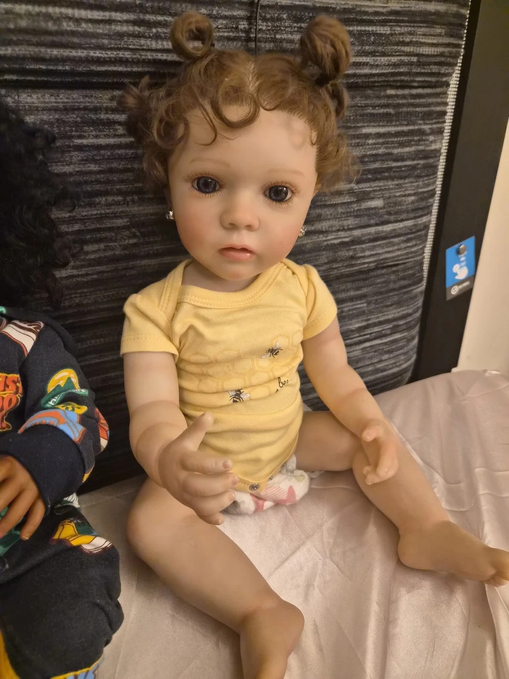 Reborn Baby Doll in Yellow Onesie with Curly Brown Hair